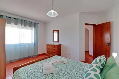 a bedroom with a bed and a dresser and a window at Albufeira Beach 1 by Homing in Albufeira