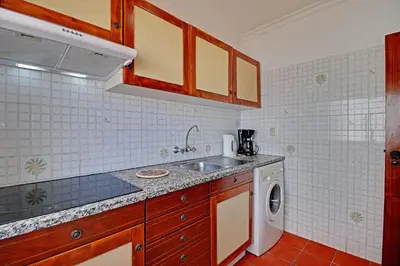 a kitchen with a sink and a washing machine at Albufeira Beach 1 by Homing in Albufeira