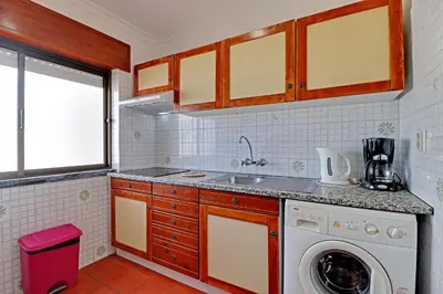 a kitchen with a sink and a washing machine at Albufeira Beach 1 by Homing in Albufeira