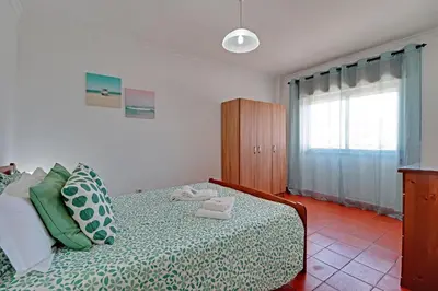 a bedroom with a bed with two towels on it at Albufeira Beach 1 by Homing in Albufeira