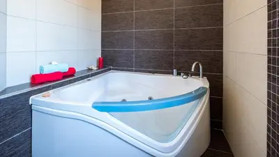 a bath tub in a bathroom with brown tiles at Villa Laguna by Algarve Vacation in Albufeira