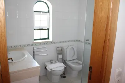 a bathroom with a toilet and a sink and a mirror at Villa V2 Z in Olhos de Água