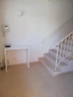 a staircase in a room with a white table at Villa V2 Z in Olhos de Água