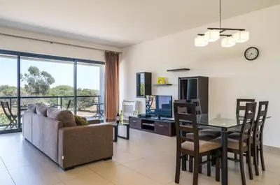 a living room with a couch and a table and a television at BmyGuest - Cavalo Preto Beach Apartment in Loulé