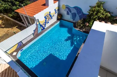 a swimming pool in a house with a painting on it at Albuera Villa in Albufeira