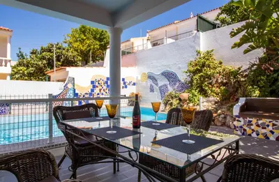 a patio with a table with wine glasses on it at Albuera Villa in Albufeira