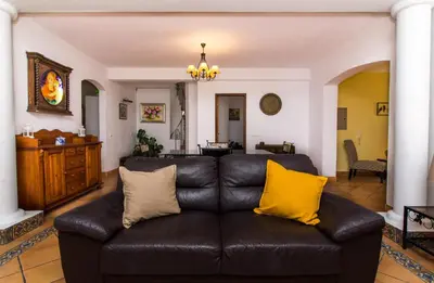 a living room with a black leather couch with yellow pillows at Albuera Villa in Albufeira