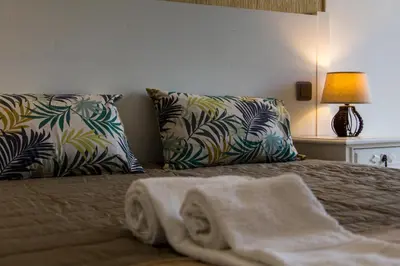 a bed with two pillows and a towel on it at Albuera Villa in Albufeira