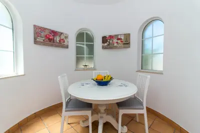 a white dining room with a white table and chairs at Albuera Villa in Albufeira