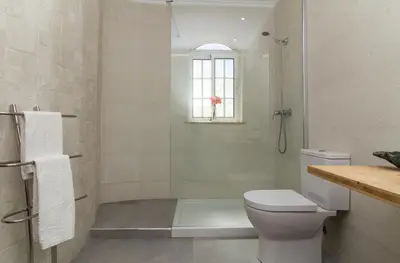 a bathroom with a shower and a toilet and a window at Albuera Villa in Albufeira