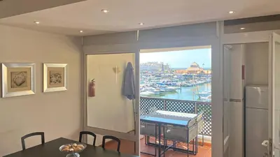 a kitchen with a table and a balcony with a view of a harbor at Penthouse Duplex Marina Plaza T1 HsR Marina Vilamoura in Vilamoura