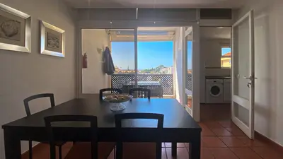 a kitchen and dining room with a table and chairs at Penthouse Duplex Marina Plaza T1 HsR Marina Vilamoura in Vilamoura
