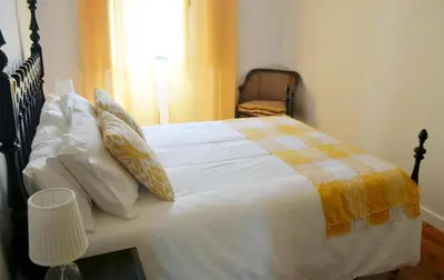 a bedroom with a large bed with white sheets and pillows at Casa aOrta in Faro