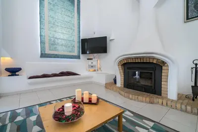 a living room with a fireplace and a table at Villa Lageado by IntiHolidays in Albufeira