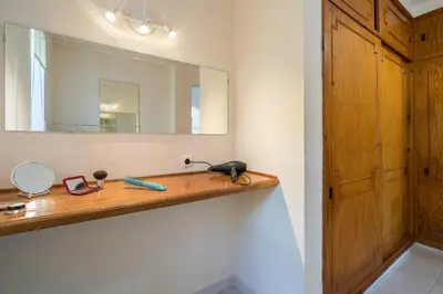 a bathroom with a wooden shelf and a mirror at Villa Lageado by IntiHolidays in Albufeira