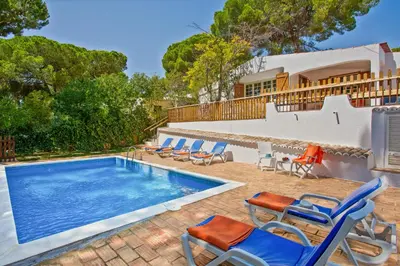 a bedroom with a large bed with blue pillows at Villa Namibe na Quinta da Balaia in Albufeira