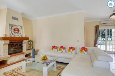 a living room with a white couch and a fireplace at Villa Mikael - Free Wi-Fi - Aircon - Private Pool by bedzy in Albufeira