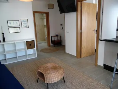 a living room with a door and a stool in a room at Paradise in Olhos D'água Beach in Albufeira