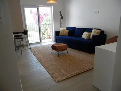 a living room with a blue couch and a stool at Paradise in Olhos D'água Beach in Albufeira
