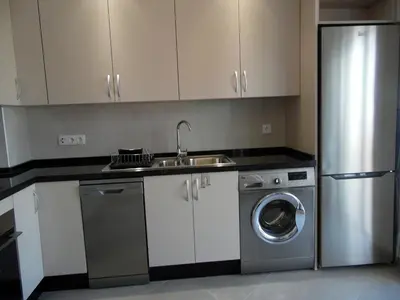 a kitchen with a sink and a washing machine at Paradise in Olhos D'água Beach in Albufeira