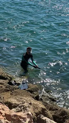 a man standing in the water with a surfboard at Bellavista Modern Comfort, 3 Balcony, Family Apartment with Wi-Fi in Albufeira