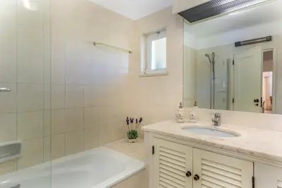 a bathroom with a sink and a shower and a mirror at FLH Balaia Village Apartment with Pool I in Olhos de Água