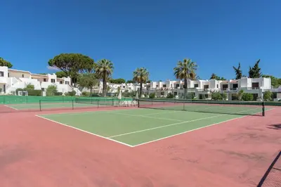 a tennis court with two tennis rackets on it at FLH Balaia Village Apartment with Pool II in Olhos de Água