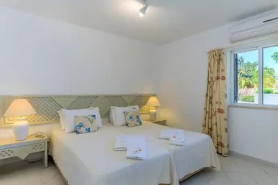 a bedroom with two beds and a window at FLH Balaia Village Apartment with Pool II in Olhos de Água