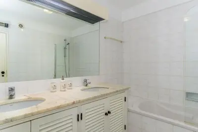a bathroom with two sinks and a tub and a mirror at FLH Balaia Village Apartment with Pool II in Olhos de Água