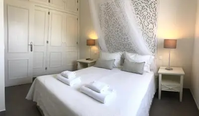 a bedroom with a white bed with two towels on it at Casa Netos in Galé