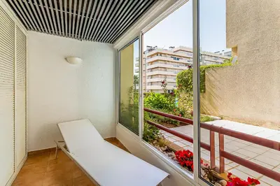 a balcony with a white bench and a large window at Onde a Marina é Casa T2 HsR Vilamarina in Vilamoura