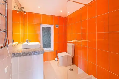 an orange bathroom with a toilet and a sink at Onde a Marina é Casa T2 HsR Vilamarina in Vilamoura