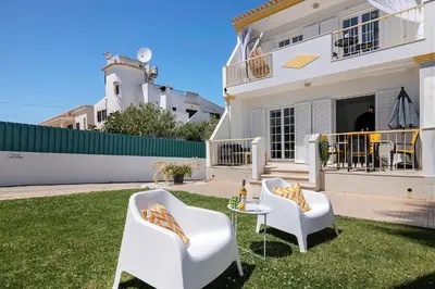 a garden with a tree stump with a pot on it at Villa Paradise in Olhos de Água