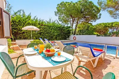 a bedroom with a large bed with red curtains at Villa Simão in Quinta da Balaia in Albufeira