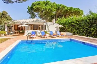 a dining room with a wooden table and chairs at Villa Simão in Quinta da Balaia in Albufeira