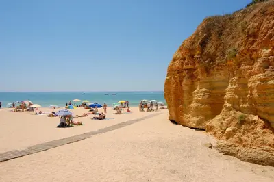 a group of people on a beach with umbrellas at Villa Simão in Quinta da Balaia in Albufeira