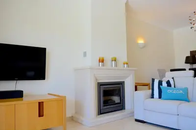a living room with a fireplace and a white couch at VILA CRISTINA MAR (8 guests and oceanview) in Albufeira