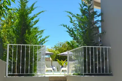 a patio with two palm trees and white chairs at VILA CRISTINA MAR (8 guests and oceanview) in Albufeira