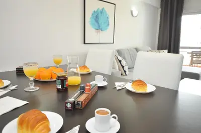 a dining room table with croissants and orange juice at Tenis Golf Mar by OCvillas in Quarteira