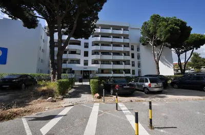 a parking lot with cars parked in front of a building at Tenis Golf Mar by OCvillas in Quarteira