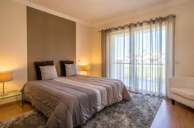 a bedroom with a large bed and a large window at Villa Cantinho by Intiholidays in Albufeira