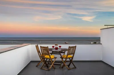 a table and chairs on a balcony with a view of the ocean at Praia Mar by OCvillas in Albufeira