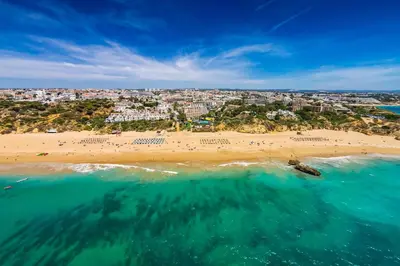 an aerial view of a beach with a city in the background at Forte São João Villas da Praia in Albufeira
