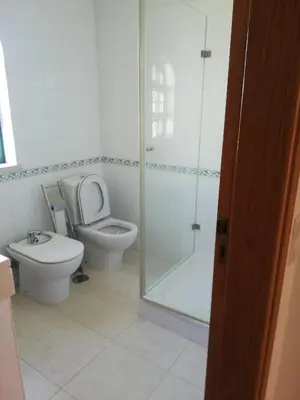 a bathroom with a shower and a tub and a sink at Villa V2 AA in Olhos de Água
