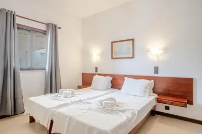 a bedroom with two beds with white sheets and a window at Bellavista Jardim By BeGuest in Albufeira