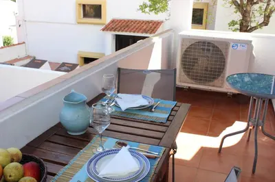 a table with two wine glasses and a bowl of fruit at A dois passos da praia in Albufeira