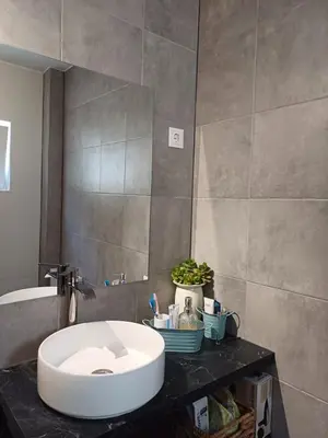 a bathroom with a white sink on a counter at A dois passos da praia in Albufeira