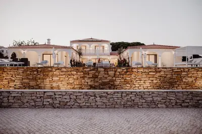 a stone wall with a house on top of it at Granvila in Quarteira