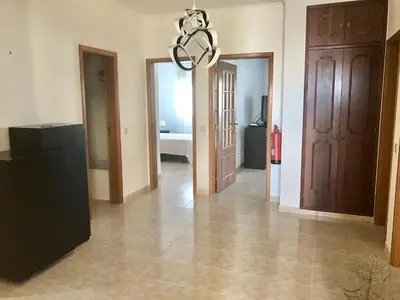 a hallway with two doors and a chandelier at Apartamento Millenium Vista Mar- 2 passos da Praia in Quarteira