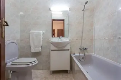 a bathroom with a toilet and a sink and a bath tub at Apartamento Millenium Vista Mar- 2 passos da Praia in Quarteira